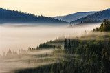 Dimhöljda bergssiluetter i morgonljus