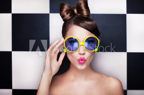 Attractive surprised young woman wearing sunglasses