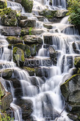 Beautiful waterfall cascades over rocks in lush forest landscape