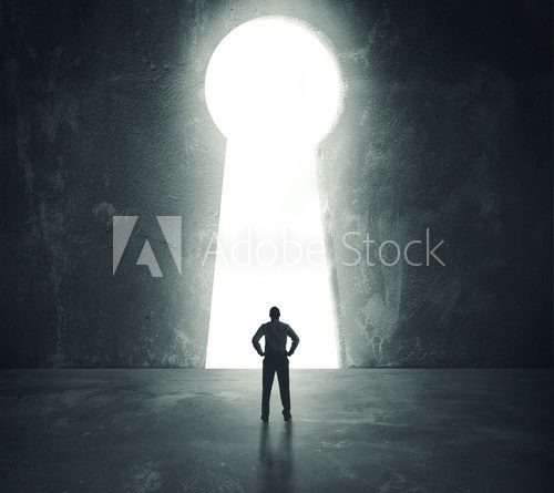 Businessman  looking through key hole
