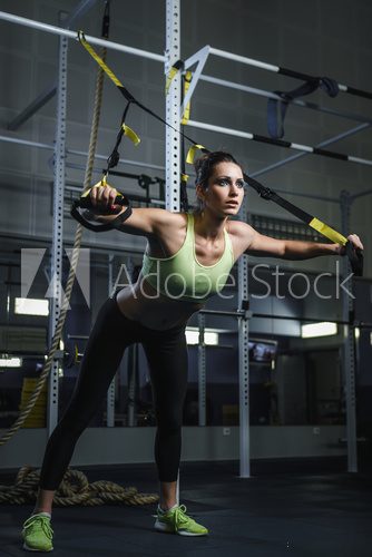 Concept: power, strength, healthy lifestyle, sport. Powerful attractive muscular woman CrossFit trainer working out at the gym