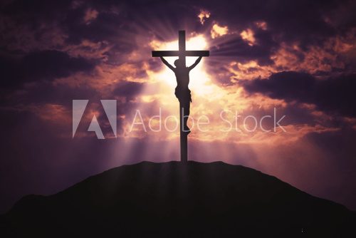 Christian cross on hill at sunrise