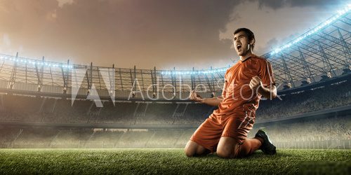 soccer player in red uniform celebrates a goal on a soccer field