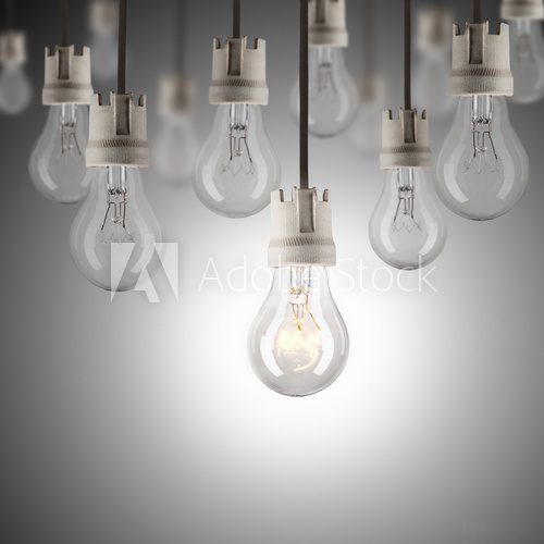 Light bulbs in row with single one shinning