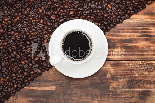 Coffee cup and beans on a rustic background