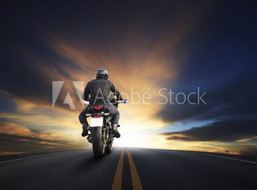 young man riding big bike motocycle on asphalt high way against