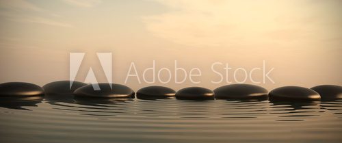 Zen stones in water on sunrise